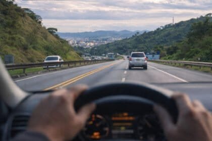 Imagem de uma estrada com sinalização de boas-vindas a Minas Gerais, destacando informações importantes sobre o IPVA 2026 no estado de Minas Gerais, incluindo calendário, descontos de até 6% e nova is.