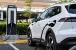 Veículo elétrico sendo carregado em estação de carregamento no Brasil, destacando a infraestrutura de energia para carros elétricos em 2026.